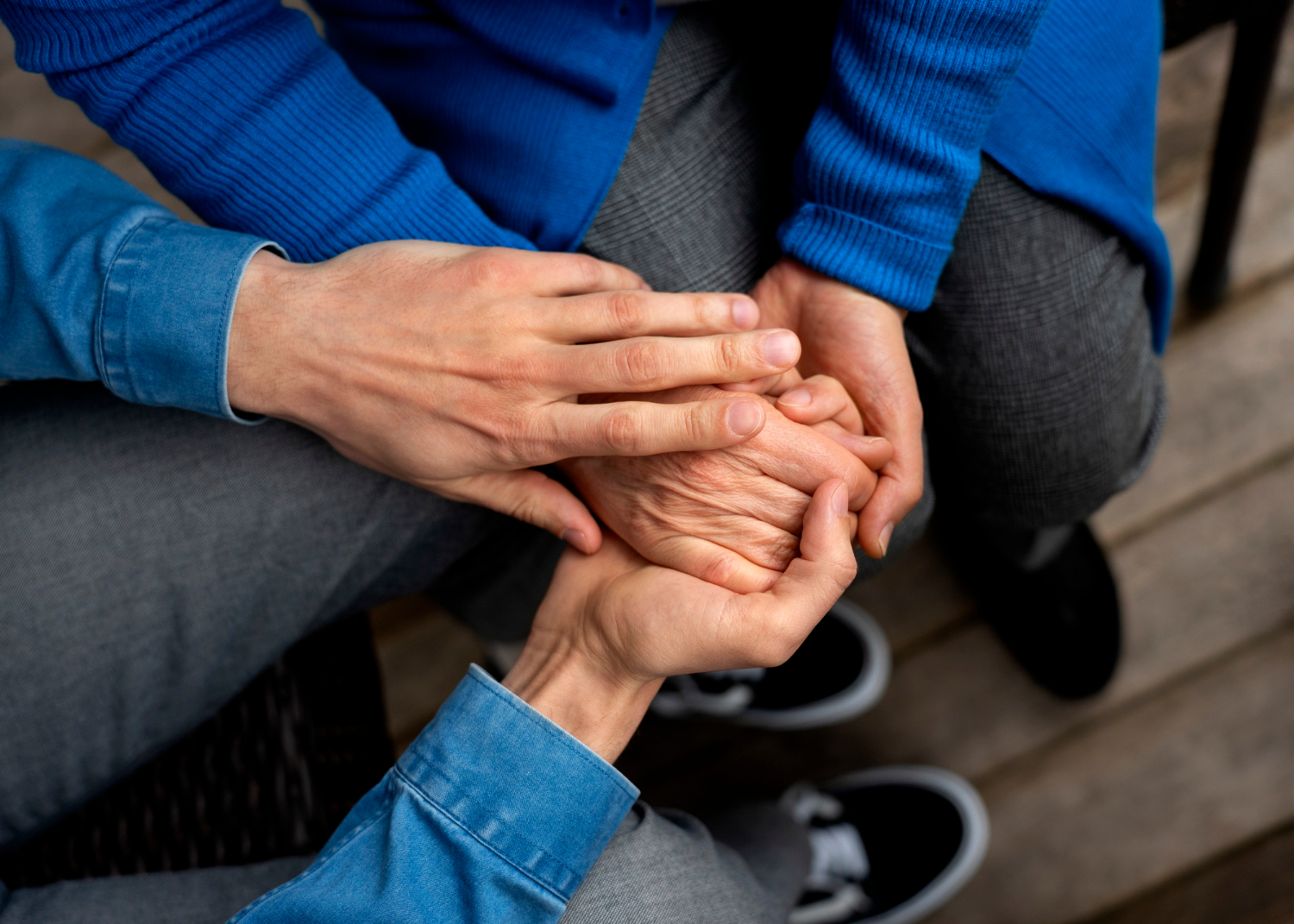 Zbliżenie na męską rękę trzymającą dłoń osoby starszej